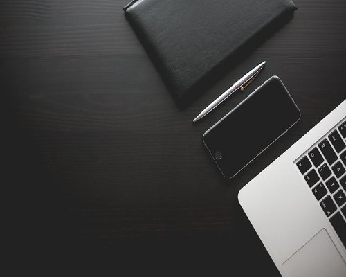 Details of a tidy desk with a notebook and pen
