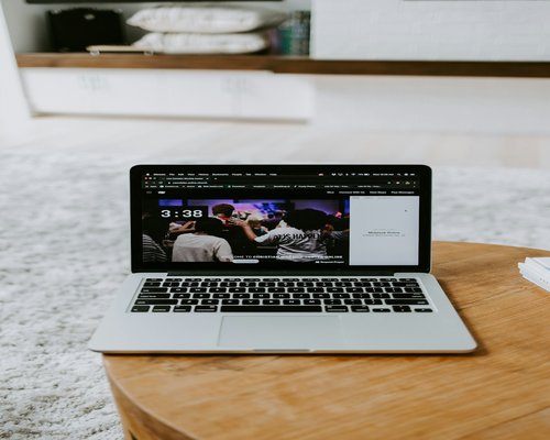 Person adjusting screen brightness on a laptop in a bright room