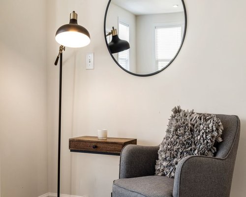 A well lit reading corner with a comfortable armchair and a lamp